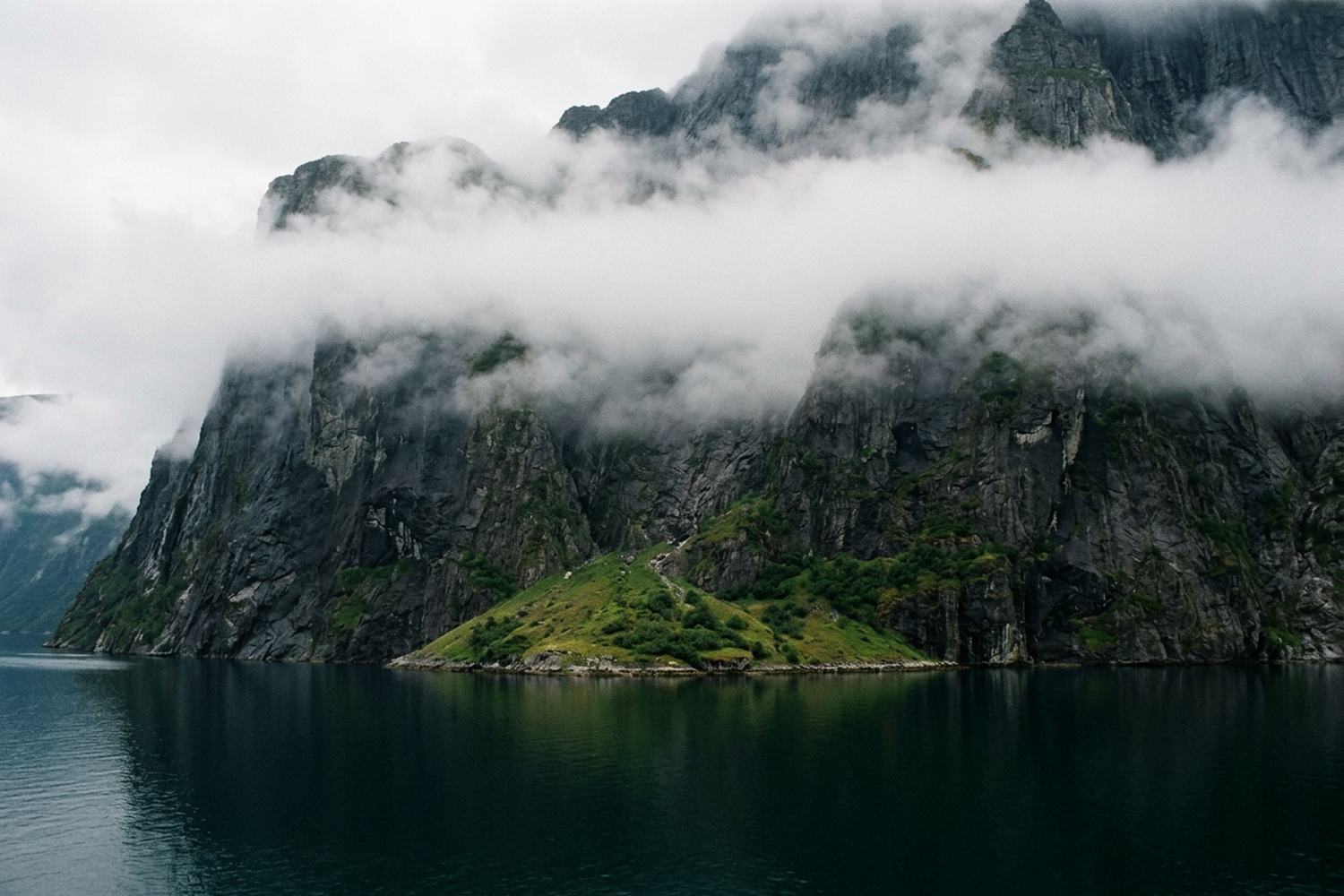 A steep fjord wall dropping straight into deep water.